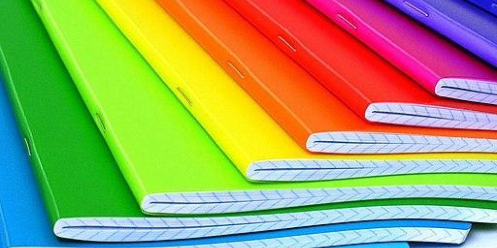 Notebooks in rainbow colours fanned out so all colours can be seen.