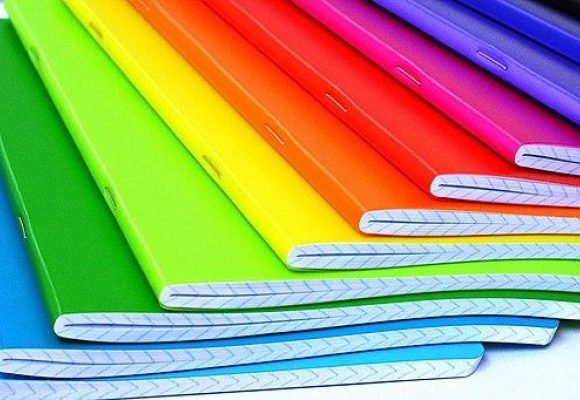 Notebooks in rainbow colours fanned out so all colours can be seen.